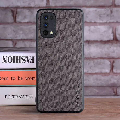 The back of a grey iphone case sitting on top of a stack of books