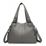 a grey leather handbag with a zipper closure