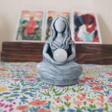 a small statue of a person sitting on a bed