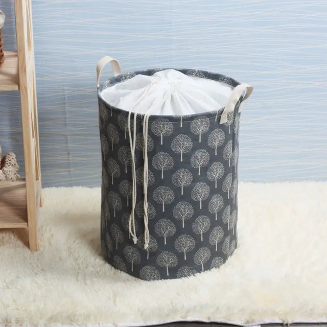 a grey and white fabric laundry basket with trees on it