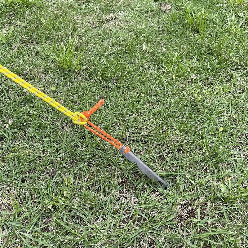 a small yellow and black shovel laying on the grass