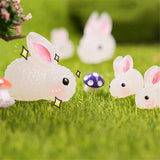 a group of plastic rabbits sitting on top of grass