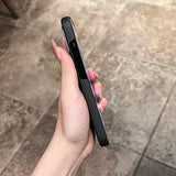 Hand holding a black carbon fiber phone case.