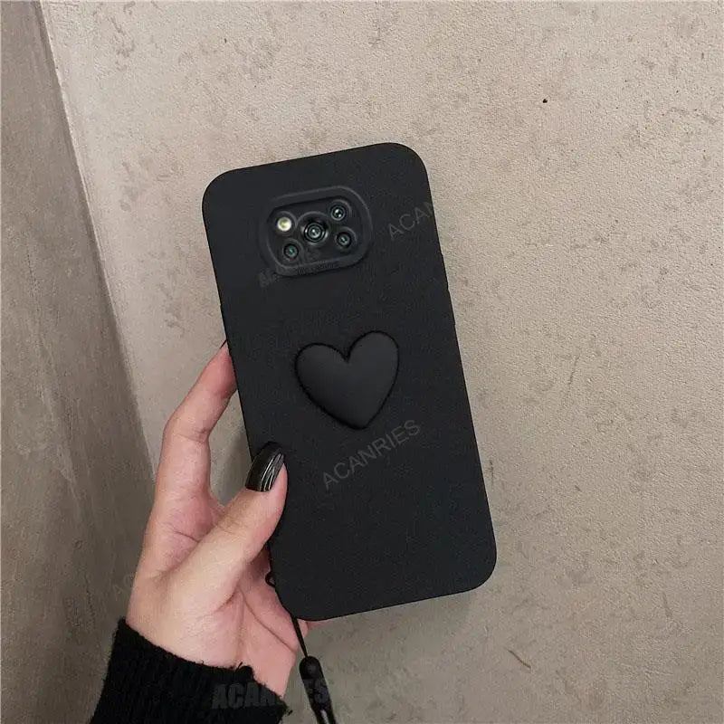 A hand holding a black heart phone case