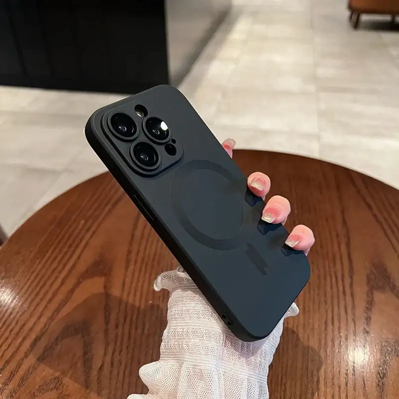 a hand holding a black iphone case