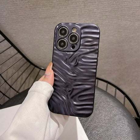 A hand holding a black phone case