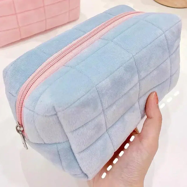 a hand holding a blue and pink fuzzyie bag