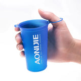 a hand holding a blue plastic cup