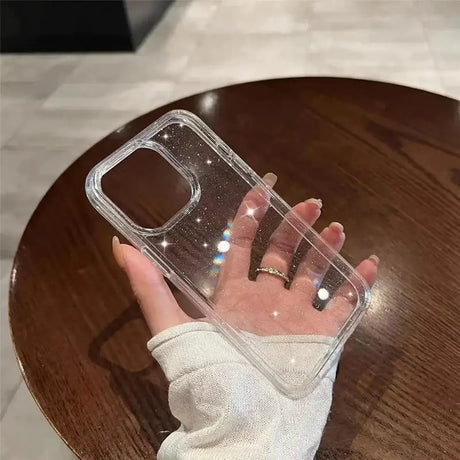 A hand holding a clear case on a wooden table