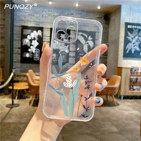 A hand holding a clear phone case with a flower design