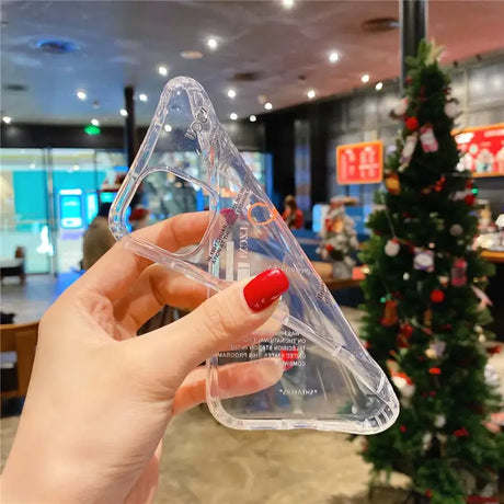 A hand holding a clear plastic triangle shaped object