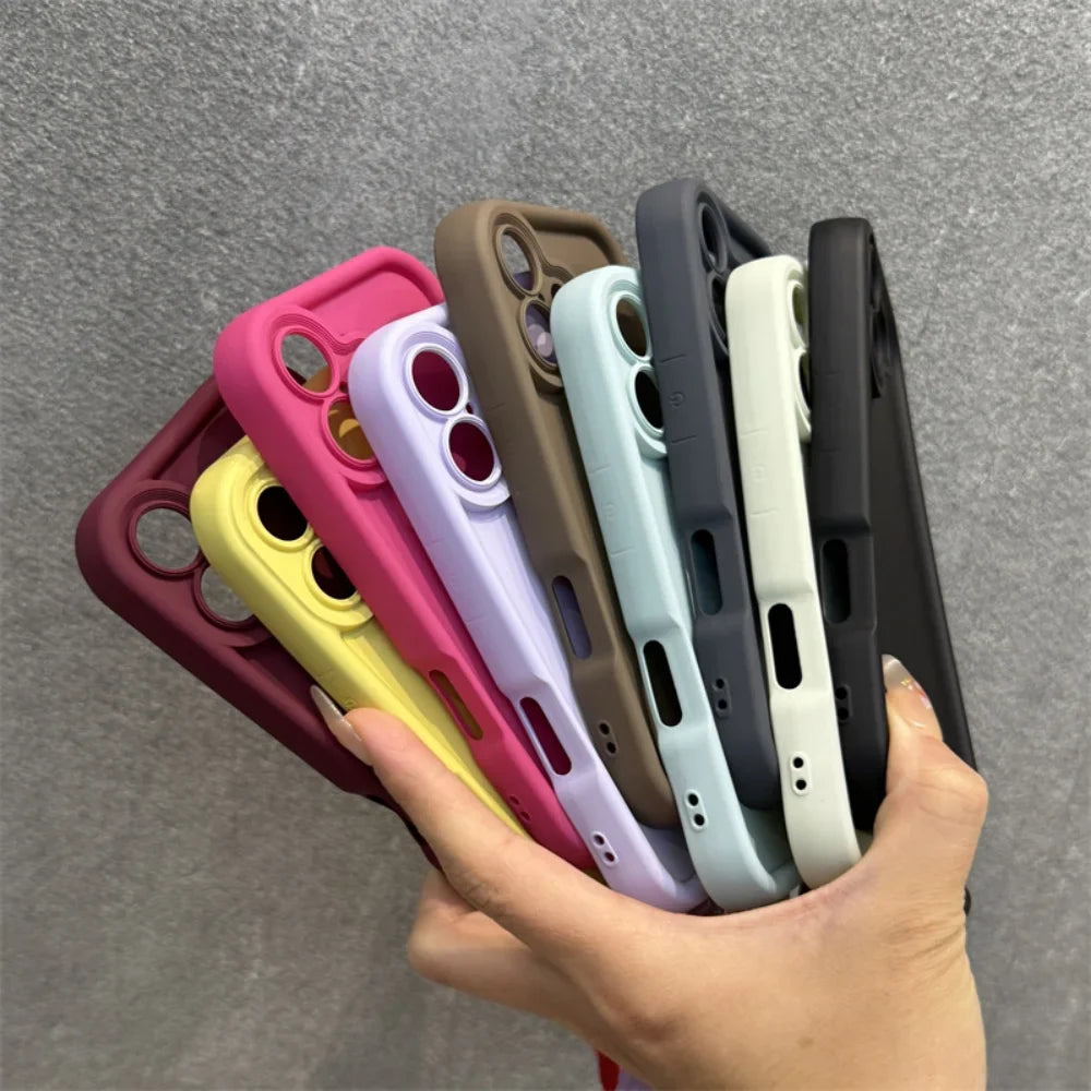 A hand holding a fanned assortment of colorful silicone phone cases.