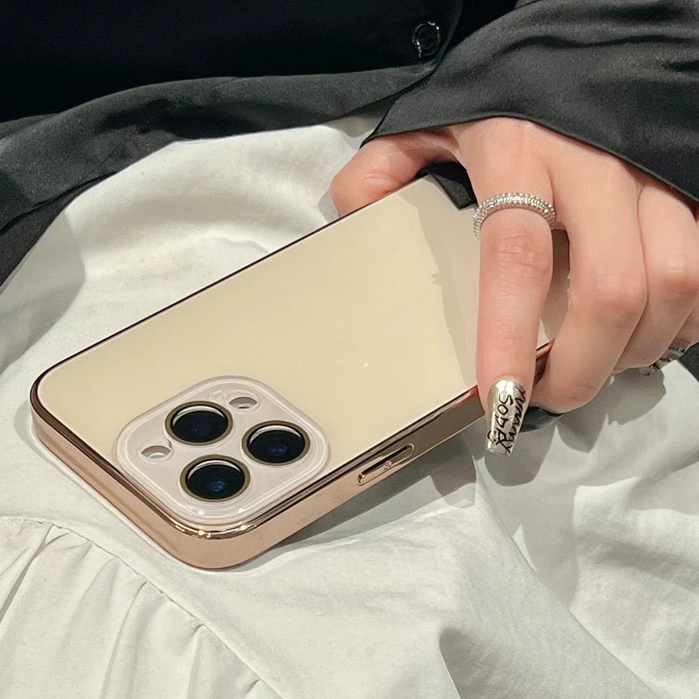 A hand holding a gold-colored smartphone with a three-lens camera and a matching gold case.