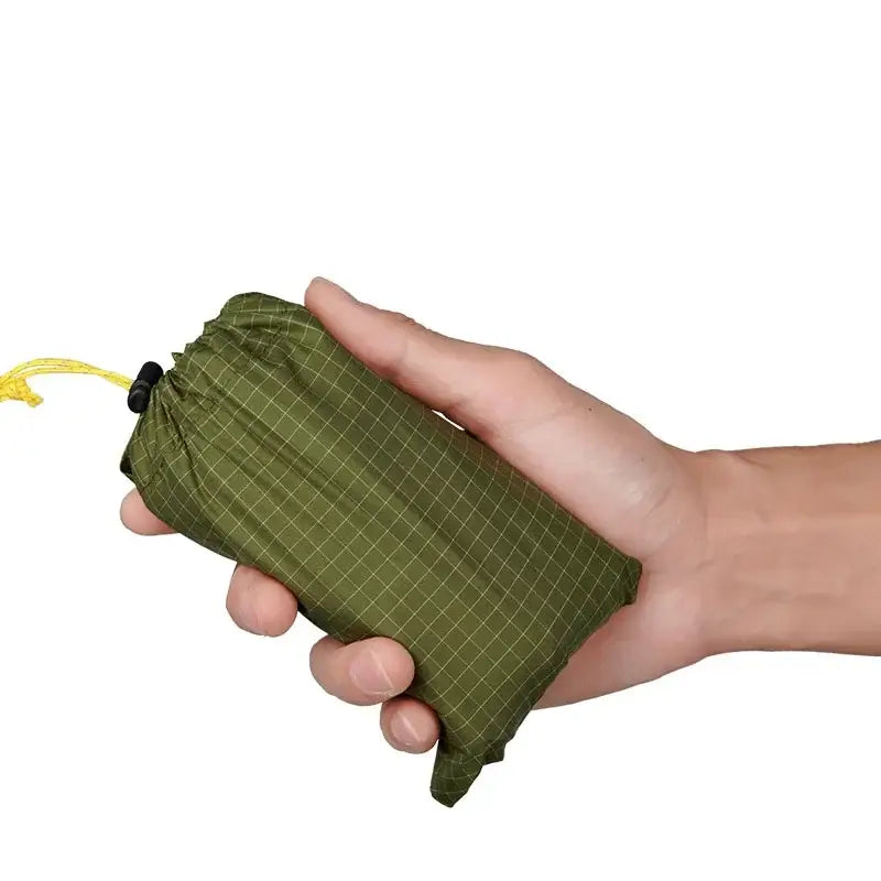 a hand holding a green bag with a yellow zipper