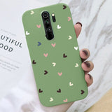 a hand holding a green phone case with hearts on it