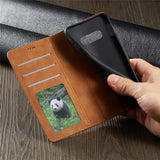 a hand holding a leather wallet with a panda face on it