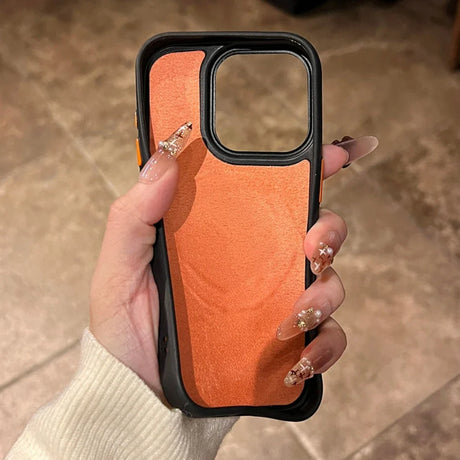 A hand holding an orange iPhone case with a black border.