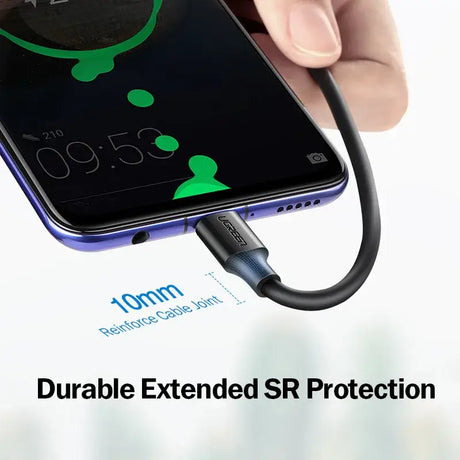 A hand holding a phone with a charging cable