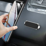 a hand holding a phone in the car