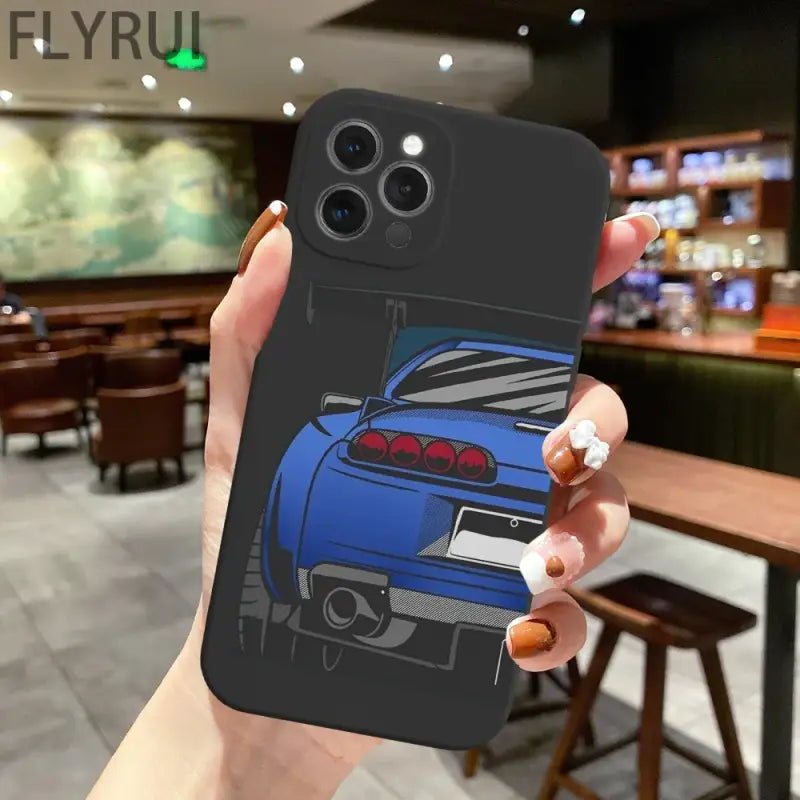 a hand holding a phone case with a blue car on it