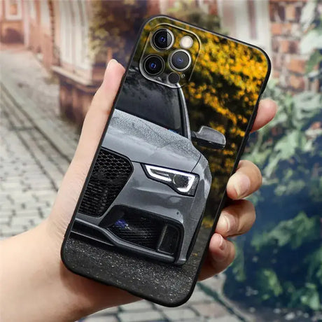 A hand holding a phone case with a car on it