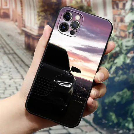 A hand holding a phone case with a car image on it