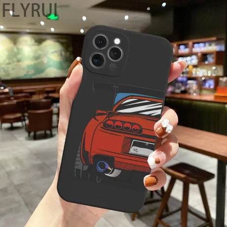 A hand holding a phone case with a car on it