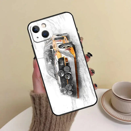 A hand holding a phone case with a car