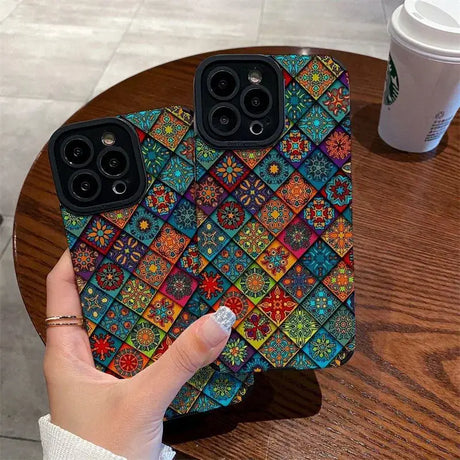 A hand holding a phone case with colorful patterns