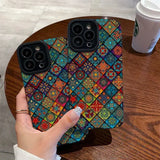 A hand holding a phone case with colorful patterns