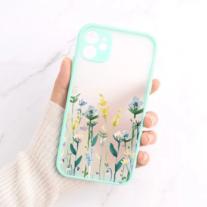 a hand holding a phone case with flowers on it