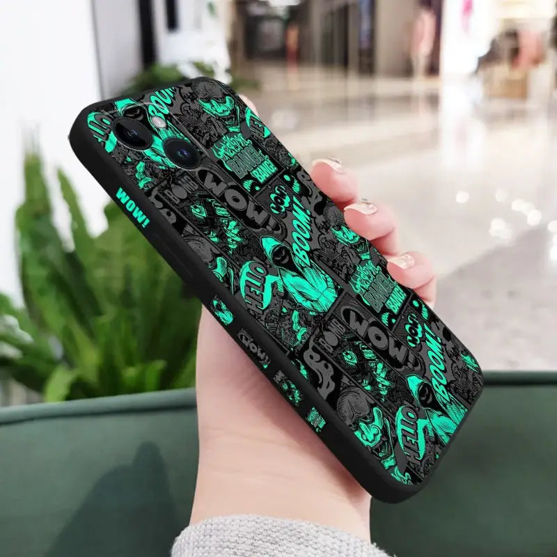 a hand holding a phone case with a green and black pattern