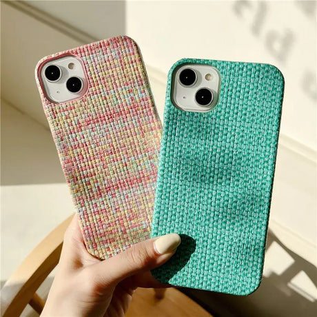A hand holding a phone case with a green and pink pattern