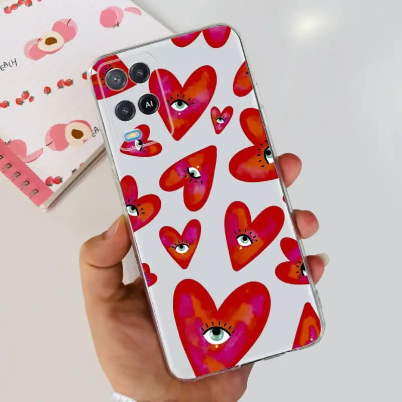 a hand holding a phone case with hearts on it
