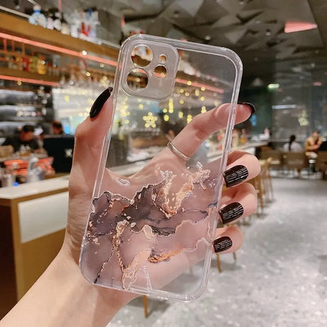 A hand holding a phone case with a marble pattern