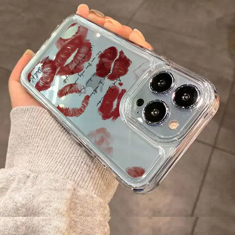 A hand holding a phone case with red lipstick on it