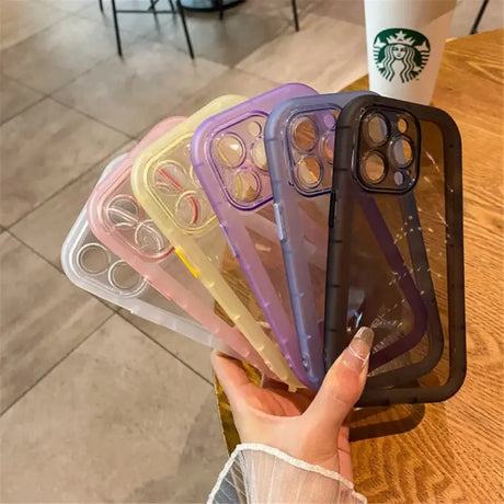 A hand holding a phone case with a starbucks cup in the background