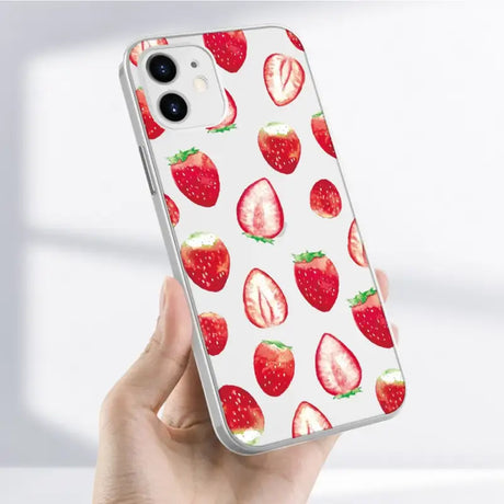 A hand holding a phone case with strawberries on it