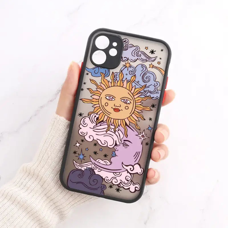 a hand holding a phone case with a drawing of a sun and clouds