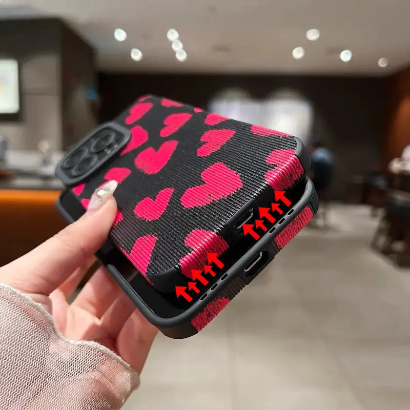 a hand holding a pink camouflage phone case