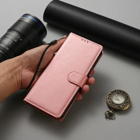 A hand holding a pink leather wallet case