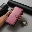 a hand holding a pink leather wallet case