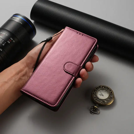 A hand holding a pink leather wallet case