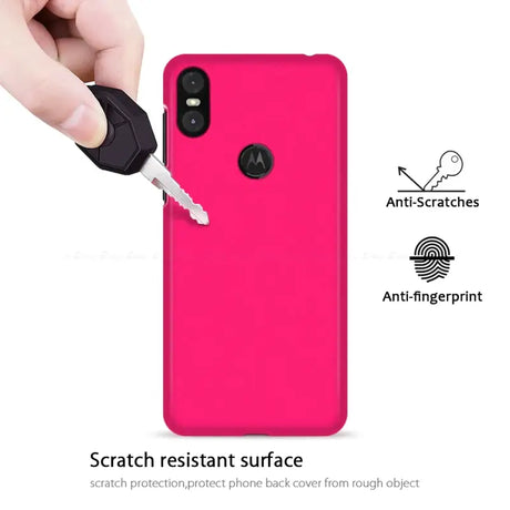 A hand holding a pink phone case with a key