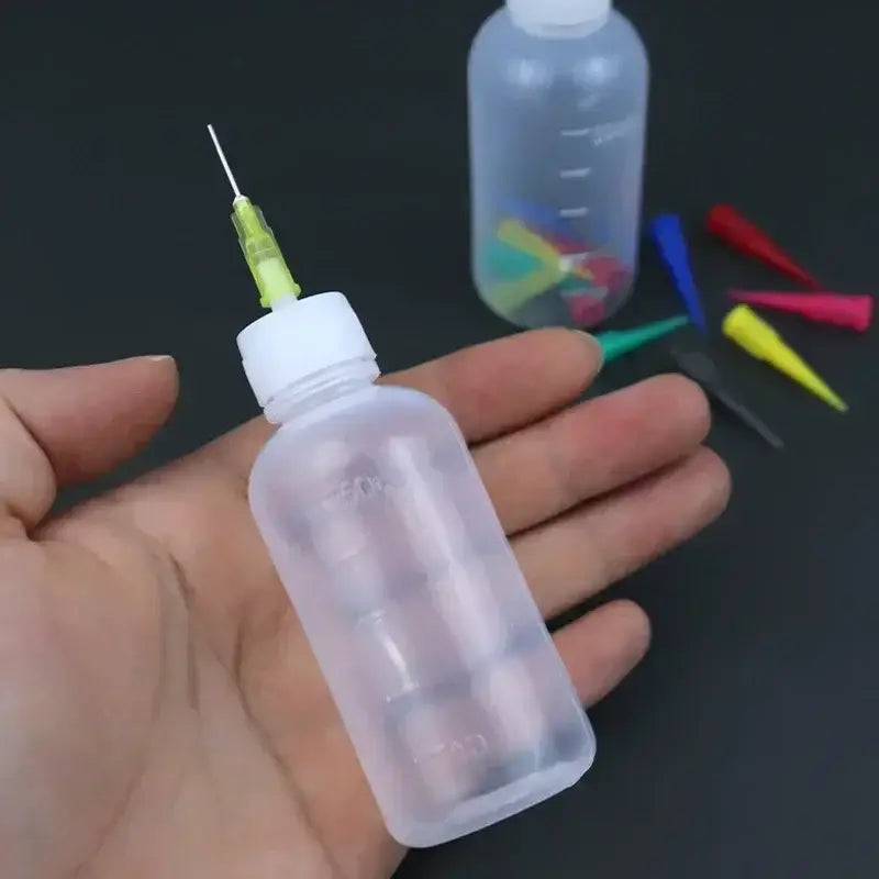 a hand holding a plastic bottle with a needle