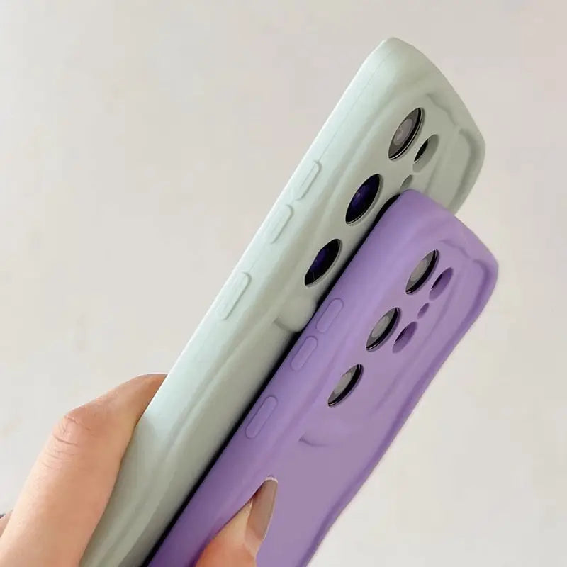 a hand holding a purple and green iphone case