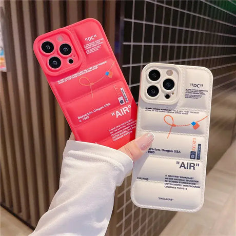 A hand holding a red iphone case with a white phone cover