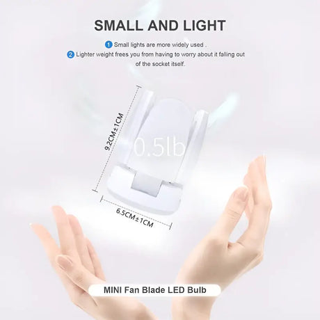 A hand holding a small white light