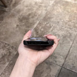 A hand holding a smartphone in a clear case.