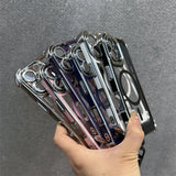 A hand holding a stack of clear smartphone cases with chrome-plated edges and camera cutouts, featuring various translucent colors and MagSafe compatibility.